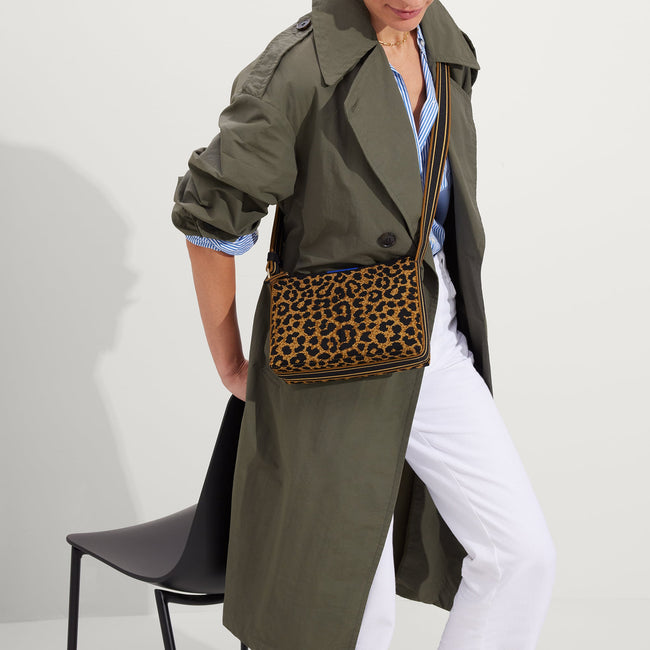 hover | The Casual Crossbody in Classic Leopard, worn as a crossbody by a model, shown from the side.