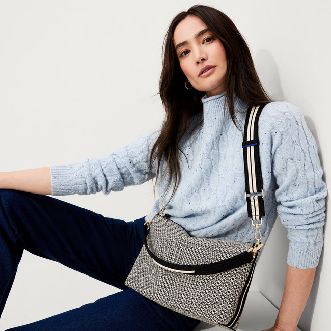The Crossbody Strap in Black and White Stripe, shown paired with The Daily Crossbody, worn by a model, shown from the front.