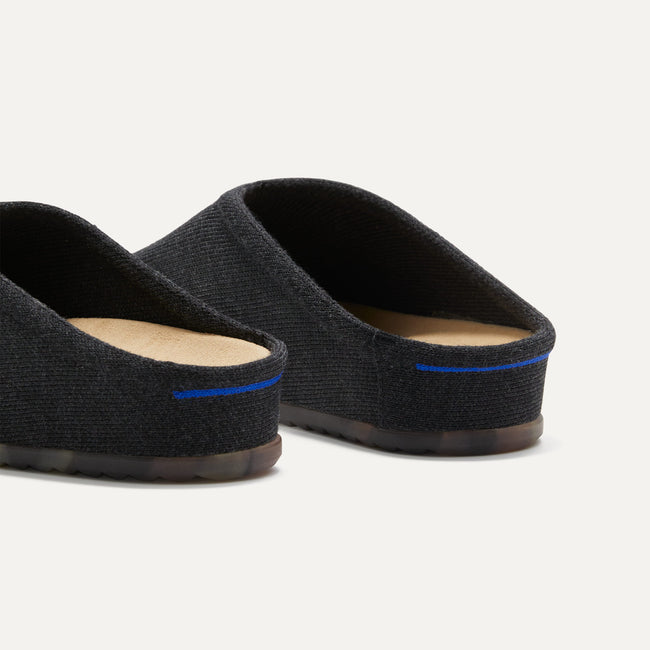 Close up of the heel of The Casual Clog in Soft Black, with Rothy's signature blue halo. 