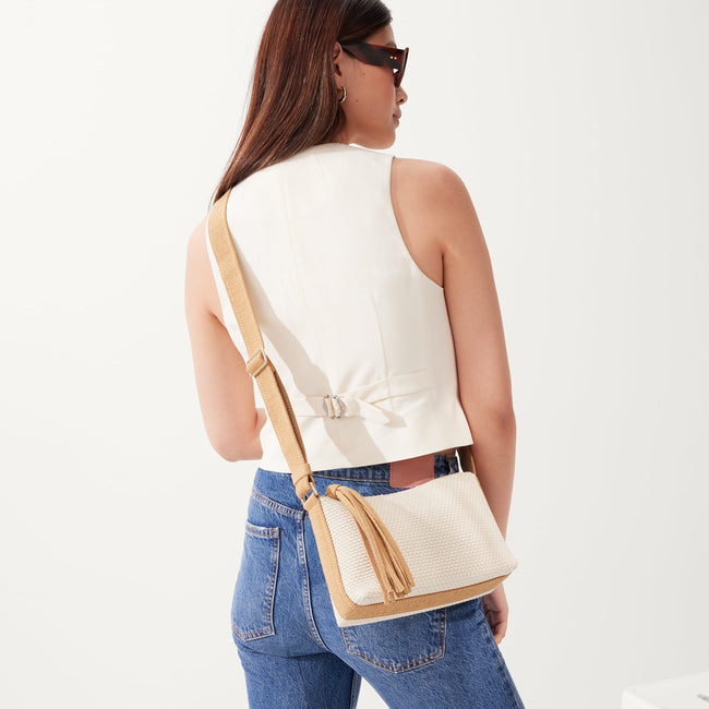 The Casual Crossbody in Coconut, worn as a crossbody by a model, shown from the side.
