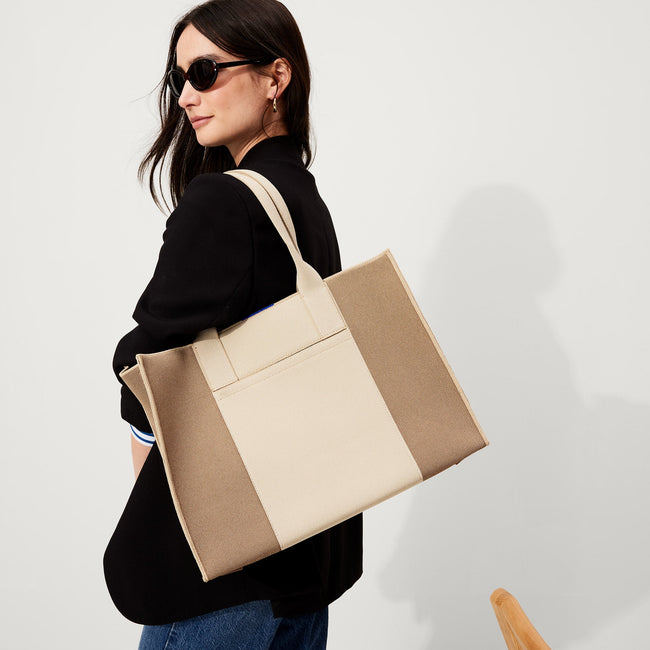 The Classic Tote in Soft Sesame, worn over the shoulder by a model, shown from the side.