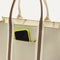 A closeup of The Classic Tote in Buttercream, focusing on the exterior zip pocket.