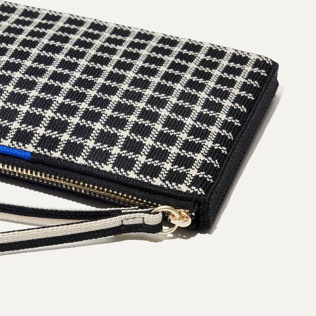 A closeup of The Wallet Wristlet in Black and Ivory Grid, focusing on the wrist strap.
