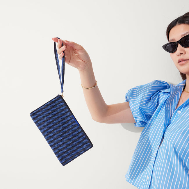 The Wallet Wristlet in Navy Stripe, held by a model, shown from the front.