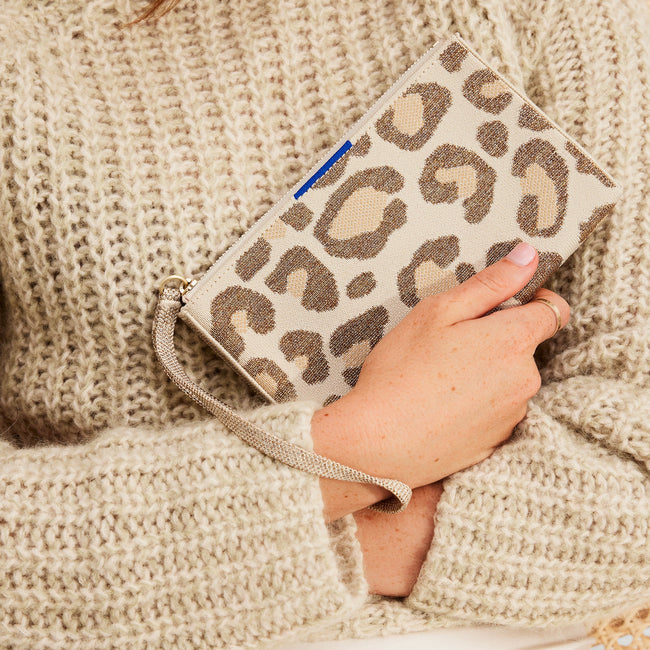 The Wallet Wristlet in Shimmer Cat, held by a model at an angle, shown from the front.
