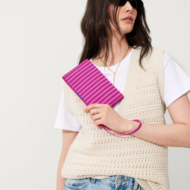 The Wallet Wristlet in Tulip Pink Colorblock, held by a model at an angle, shown from the front.