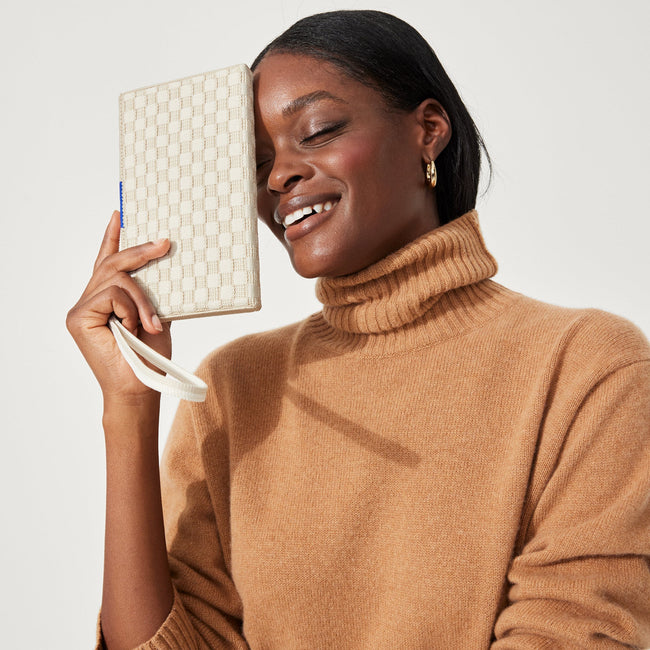 hover | The Wallet Wristlet in Vanilla Basketweave, held by a model, shown from the front.