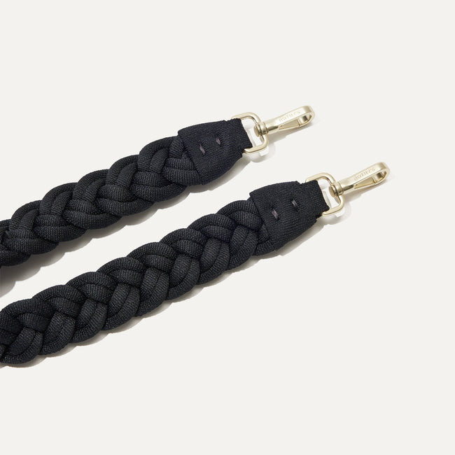 A close-up of The Braided Shoulder Strap in Black, focusing on the end snap hooks. 