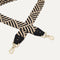 A closeup of The Crossbody Strap in Black and Ivory Woven, focusing on the end snap hooks and sliding buckle.