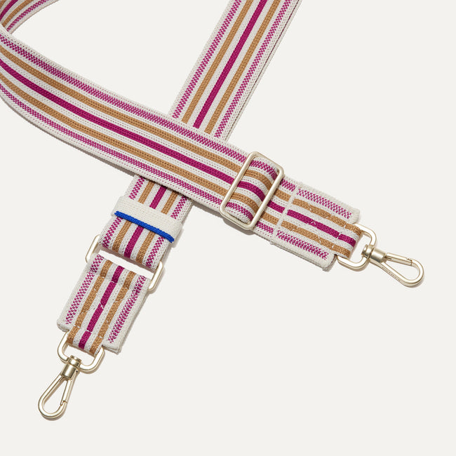 A close-up of The Crossbody Strap in Fuchsia Stripe, focusing on the end snap hooks and sliding buckle.