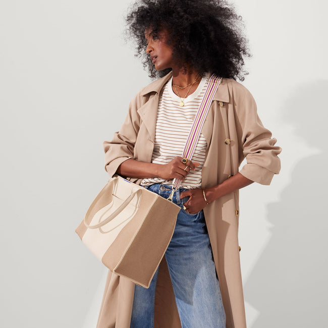 The Crossbody Strap in Fuchsia Stripe, shown paired with The Classic Tote, worn by a model, shown from the side