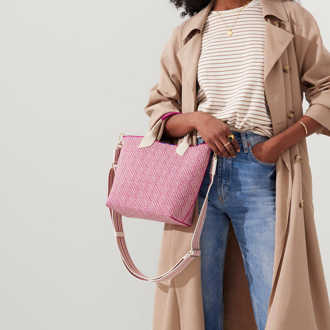 The Crossbody Strap in Fuchsia Stripe, shown paired with The Lightweight Petite Tote, worn by a model, shown from the front.
