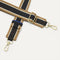A close-up of The Crossbody Strap in Khaki Stripe, focusing on the end snap hooks and sliding buckle.