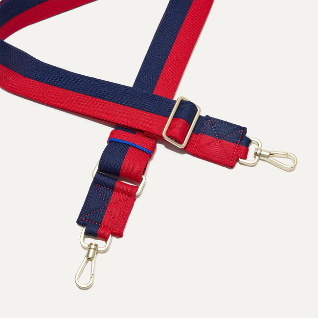 A close-up of The Crossbody Strap in Navy & Red, focusing on the end snap hooks and sliding buckle.