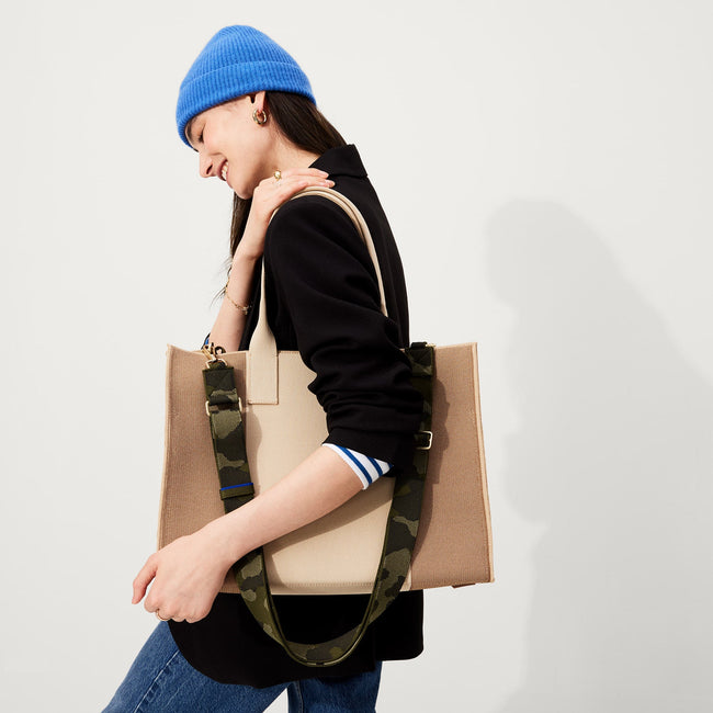 The Crossbody Strap in Spruce Camo, shown paired with The Classic Tote, worn by a model, shown from the side