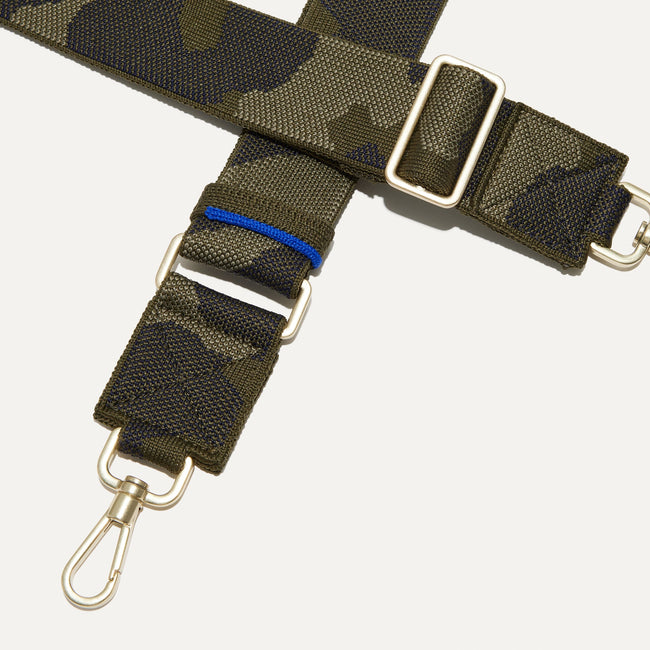 A closeup of The Crossbody Strap in Spruce Camo, focusing on the end snap hooks and sliding buckle.
