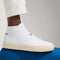 hover | Model wearing The High Top Sneaker in Bright White.