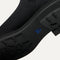 Close up of the outsoles of The Lug Boot in Onyx Black, with raised grooves for added traction. 