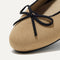 Close up of the rounded toe and bow detail of The Ballet Flat in Beige and Black.