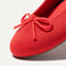 Close up of the rounded toe and bow detail of The Ballet Flat in Glamour Red. 