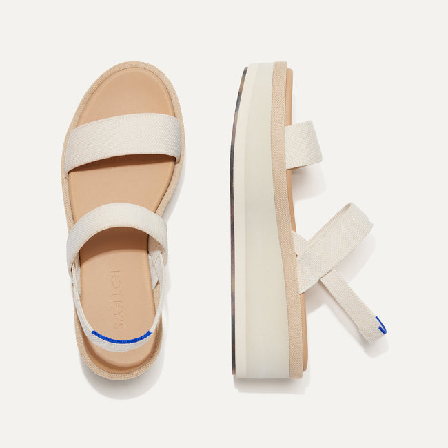 The Lightweight Wedge Sandal in Salt shown from the top, with one shoe turned on its side.