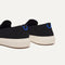 Close up of the heel of The Ravello Slip On Sneaker in Black, with Rothy's signature blue halo. 
