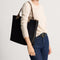 hover | Model holding The Lightweight Tote in Black Portobello.