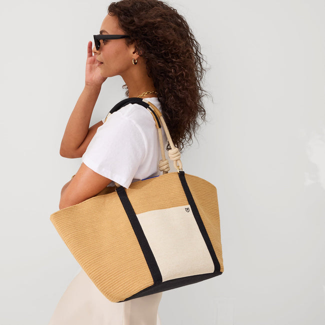 Model holding The Reversible Summer Tote in Camel.