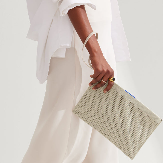 The Wallet Wristlet in Diamond Metallic, held by a model at an angle, shown from the front.