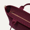 A close up of The Lightweight Zip Tote in Cabernet Check focusing on the zip closure and handles.
