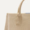 Close up look of The Classic Handbag in Soft Sesame shown laid down.