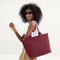 hover | Model holding The Lightweight Zip Tote in Cabernet Check.