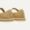 Close up of the heel of The Espadrille Mary Jane in Metallic Golden Sun, with Rothy's signature blue halo. 