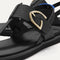 Close up of the T-strap and buckle detail of The T-Strap Sandal in Black. 