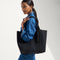 hover | Model holding The Lightweight Tote in Black Licorice.