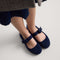 hover | Model wearing The Kids Tux Bow Mary Jane in ReVelvet™ Deep Navy.