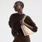 hover | Model wearing The Daily Crossbody in Oat Latte.