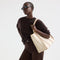 hover | The Classic Tote in Buttercream, worn over the shoulder by a model, shown from the side.