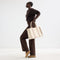 The Classic Tote in Buttercream, worn over by a model.