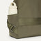A close up of the The Travel Cinch Backpack in Forest focusing on the straps, and the side pocket.