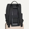 The Travel Cinch Backpack in Ink shown from the back, shown attached to a rolling suitcase using the wrap-around band.