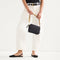 hover | Overlay::Shown with The Camera Bag (sold separately) | Alt:: Model holding The Shoulder Strap in Tortoise Chain.

