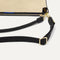The Daily Crossbody in Black and White Raffia-Knit, lying flat, showing the detachable top handle and adjustable crossbody strap.