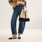  Model wearing The Cinch Bucket Bag in Black and White Raffia-Knit shown from the front.