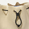A close up of The Cinch Bucket Bag in Black and White Raffia-Knit showing the drawstring closure.
