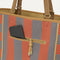 A closeup of The Two-Way Tote in Sienna, focusing on the exterior zip pocket.