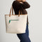 hover | Model shown carrying The Two Way Tote in Ivy, showing the reversible cream side. 