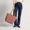 Alternate view of a model carrying The Two-Way Tote in Sienna.