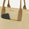 A closeup of The Classic Tote in Macadamia Open-Knit, focusing on the exterior zip pocket. 