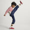 Alternate image of a child modeling The Kids Stretch Sneaker in Firecracker.